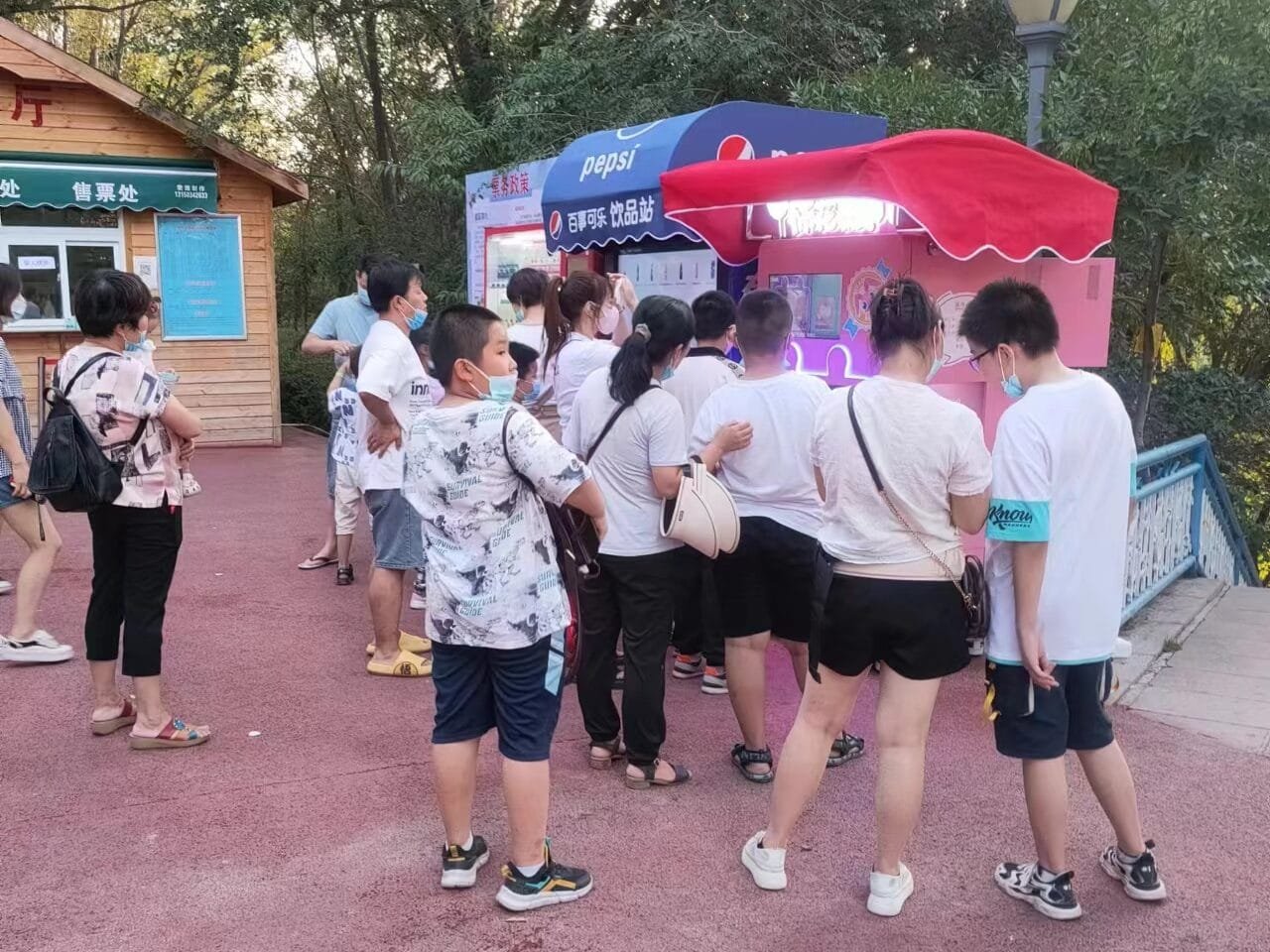 A cool automated cotton candy machine in a bustling theme park, with kids running around screaming.